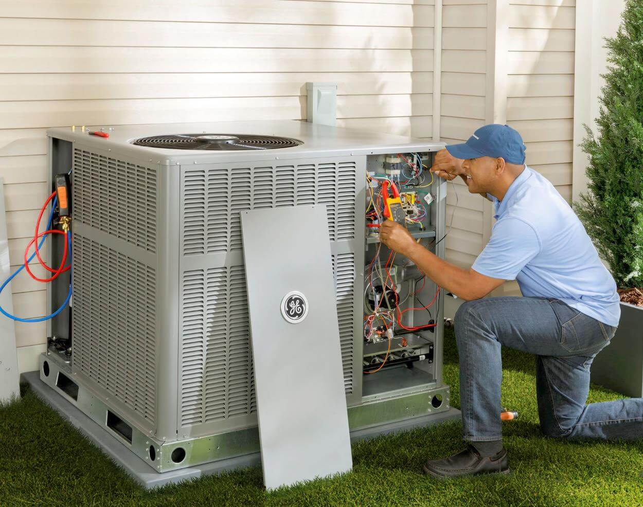 HVAC technician working on unit outside of home