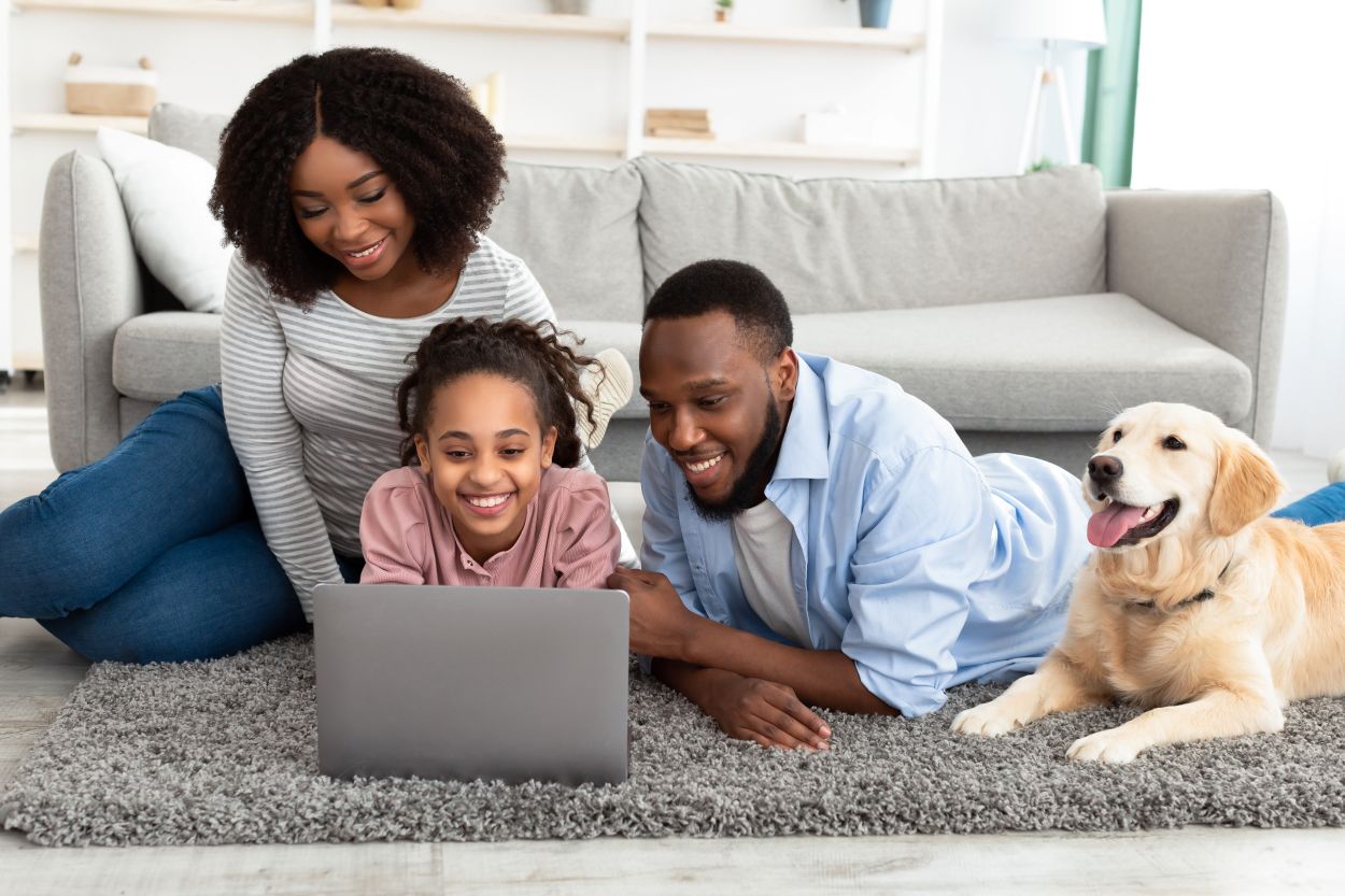 family on laptop together with dog
