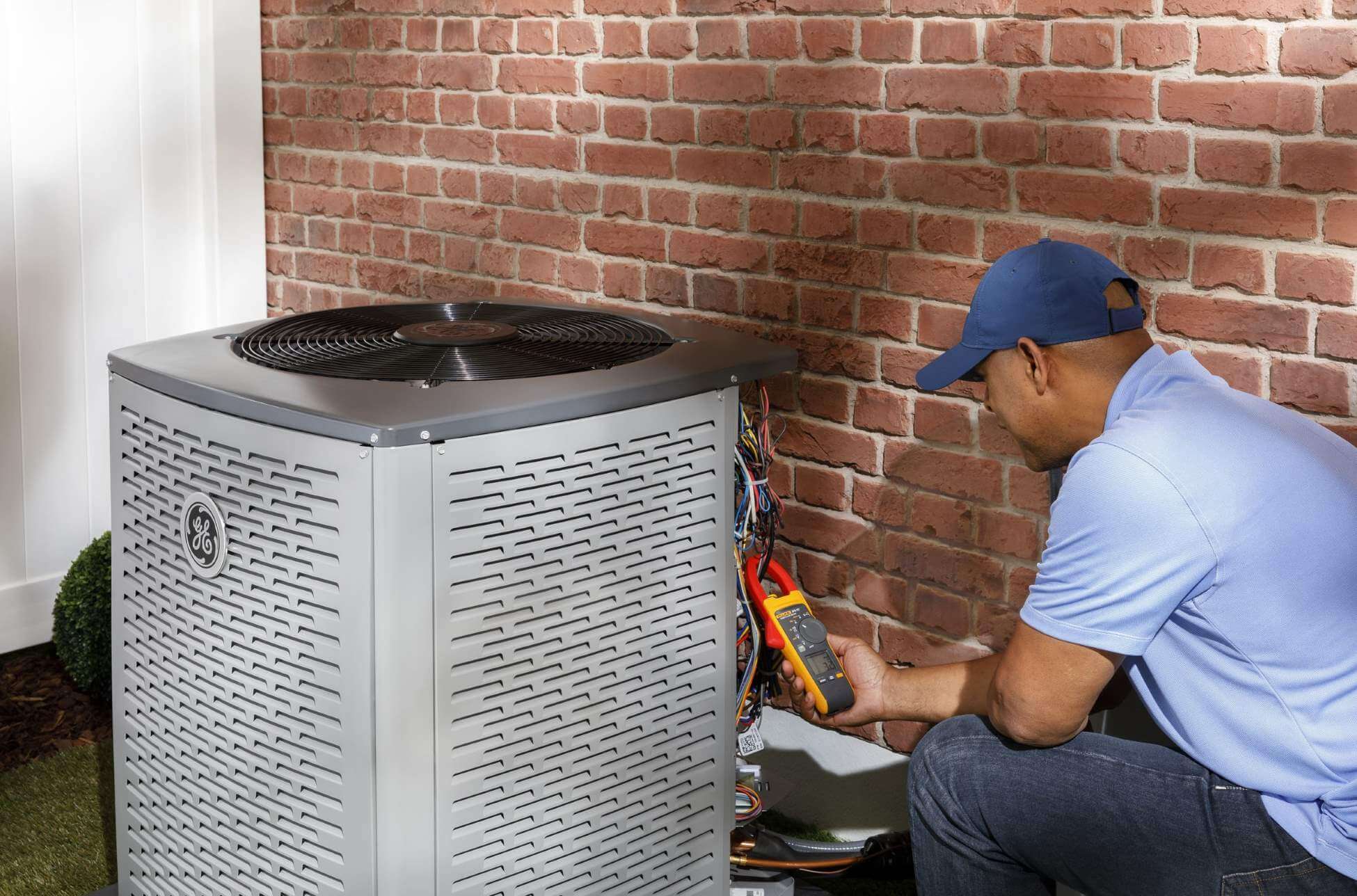 HVAC technician working on unit outside of home
